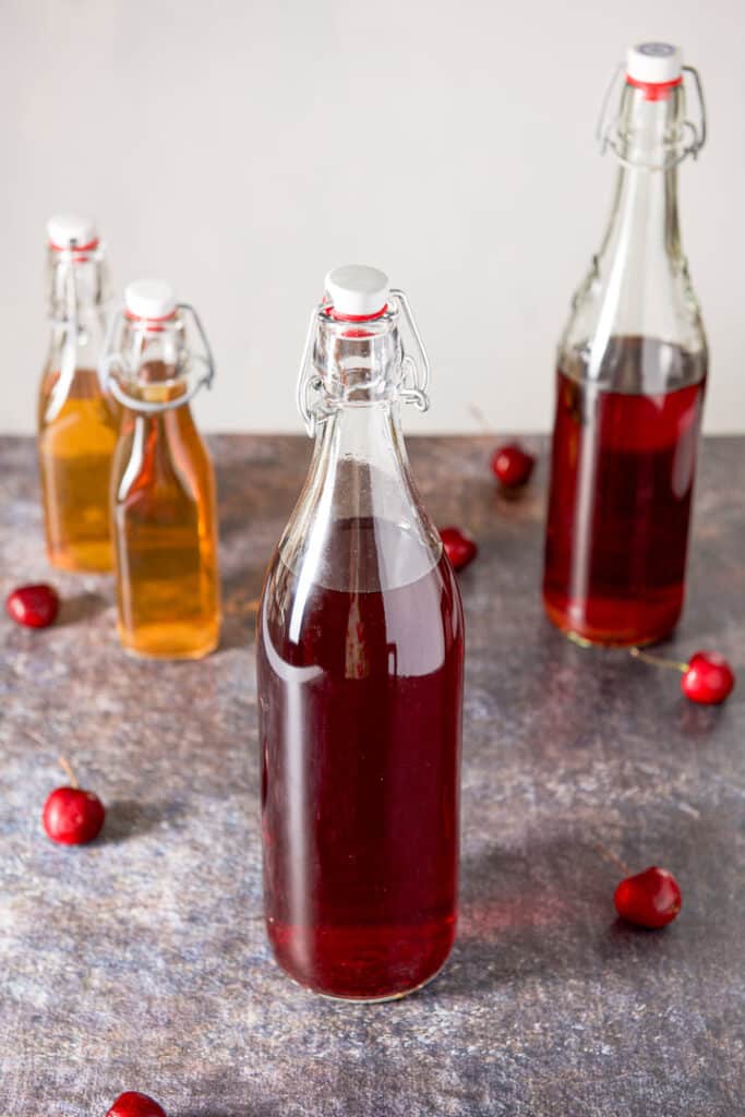 Four bottles of infused alcohol on a colorful background