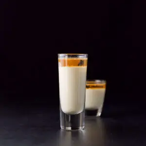 The tall glass with the eggnog on the bottom and brandy on the top - square