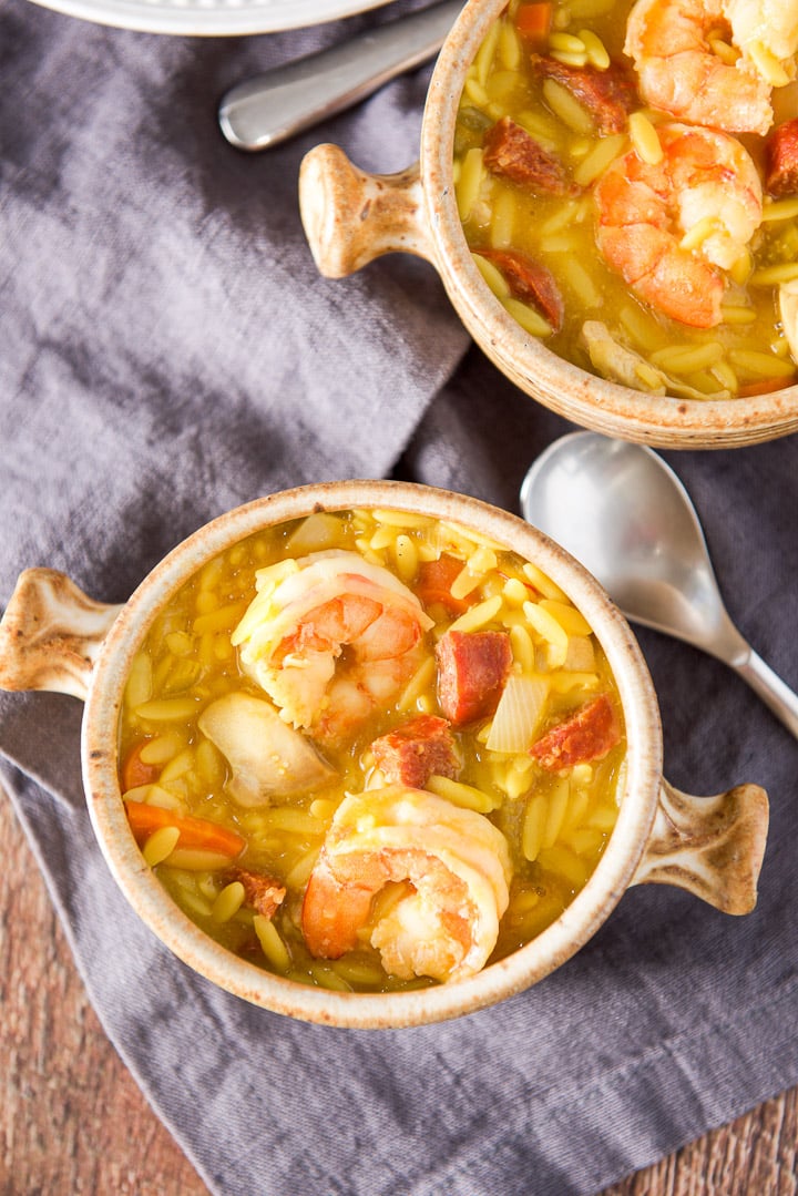 Overhead view of two crocks filled with a soup with lots of meat and orzo