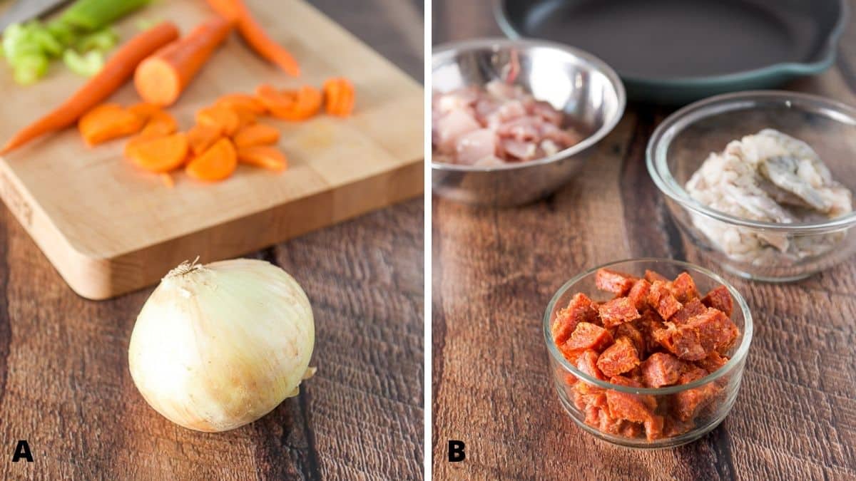 On the left - onion in front of a board with carrots and celery. On the right - chopped chorizo, shelled shrimp and cut up chicken thighs in bowls