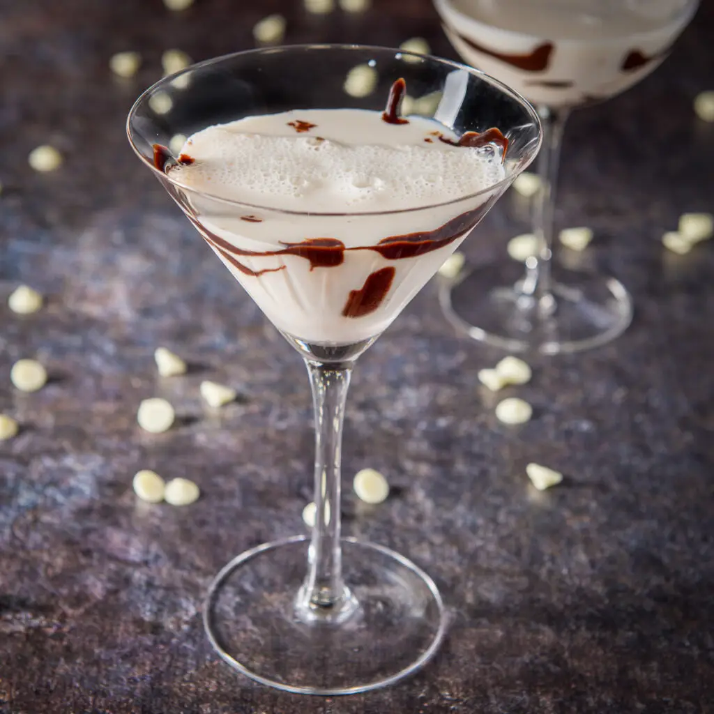 A classic martini glass filled with the milk cocktail with chocolate on the glass - square