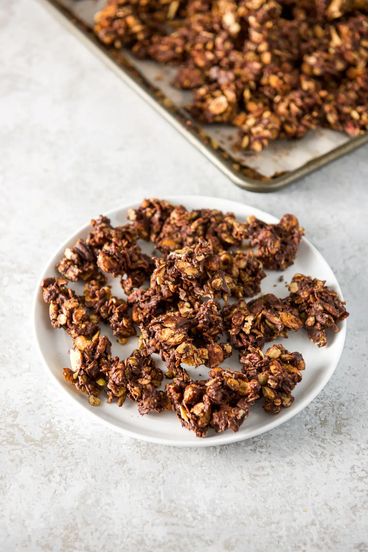 A plate of granola clusters with the pan in the background