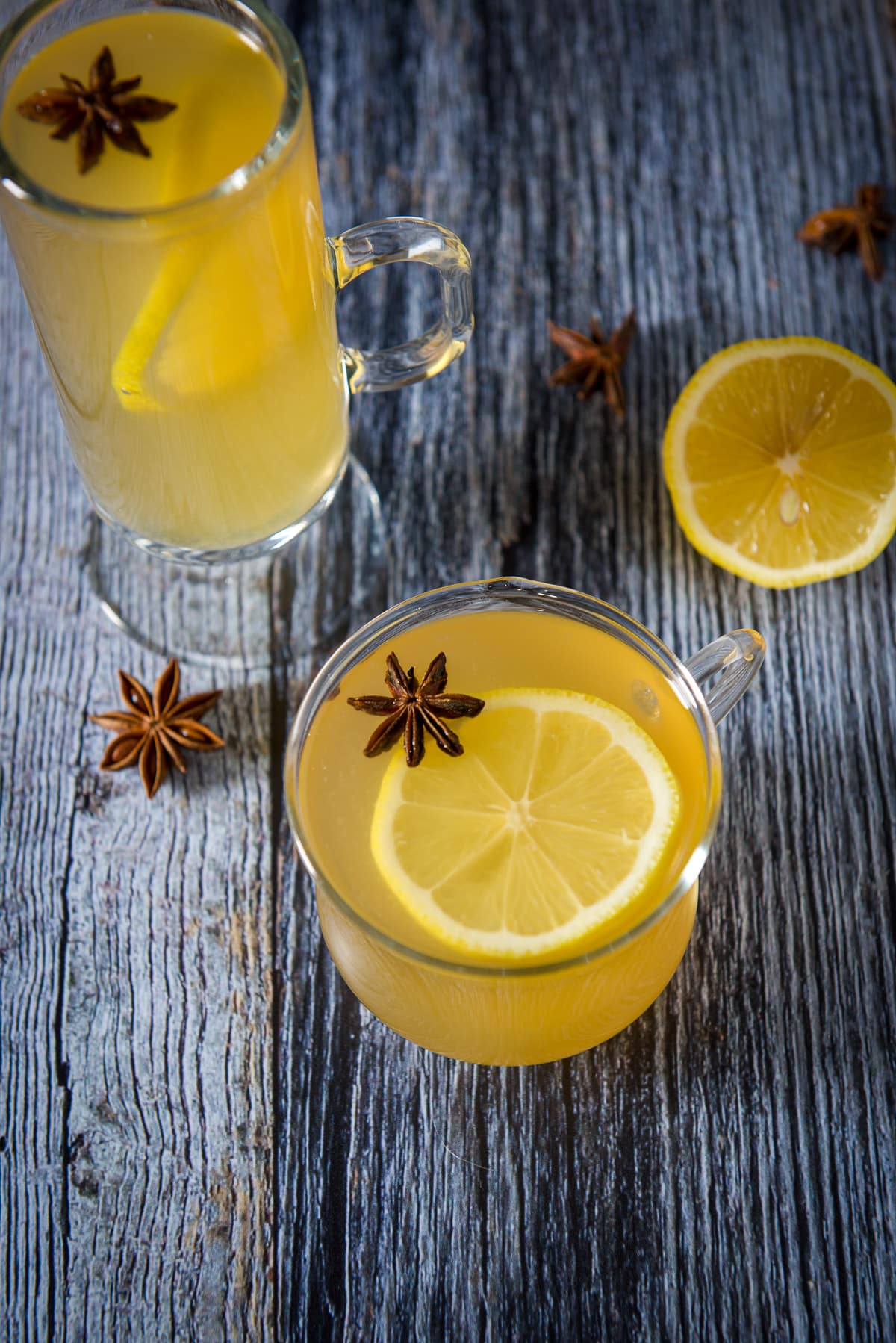 Overhead view of the two mugs filled with the warm cocktail with star anise and lemon wheels