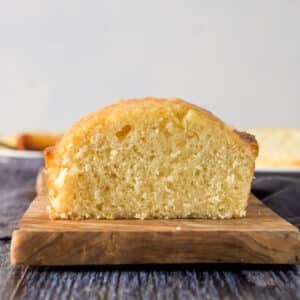 A vertical view of a wooden board with lemon bread on it