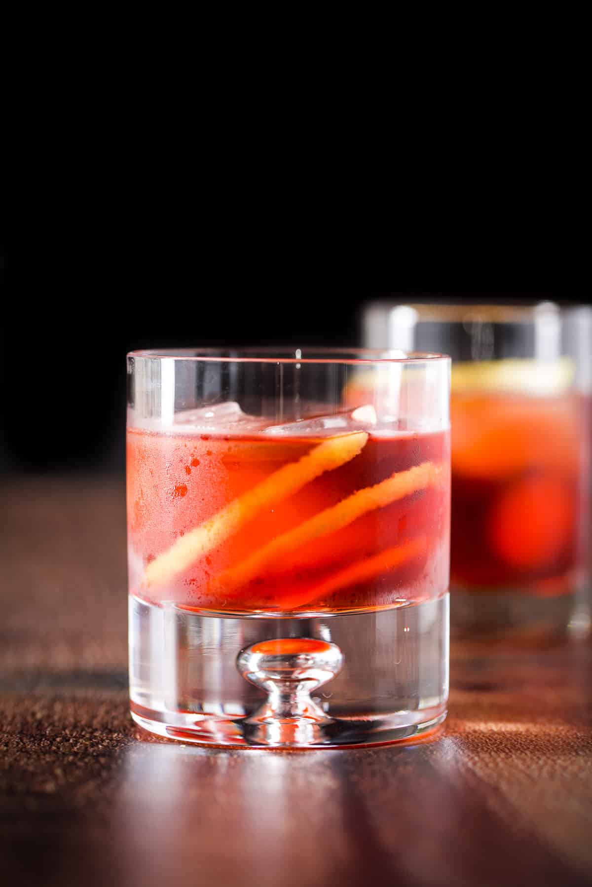 Vertical view of the bubble glass filled with the aperitif cocktail in front of a taller glass