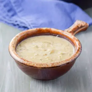 A crock of bisque with a blue napkin - square