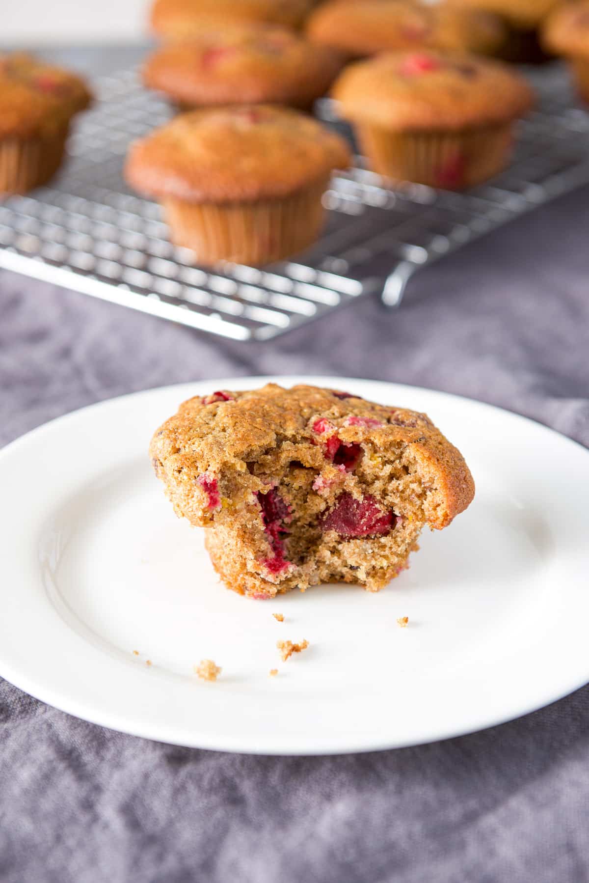 A small white plate with a muffin with a bite taken out of it