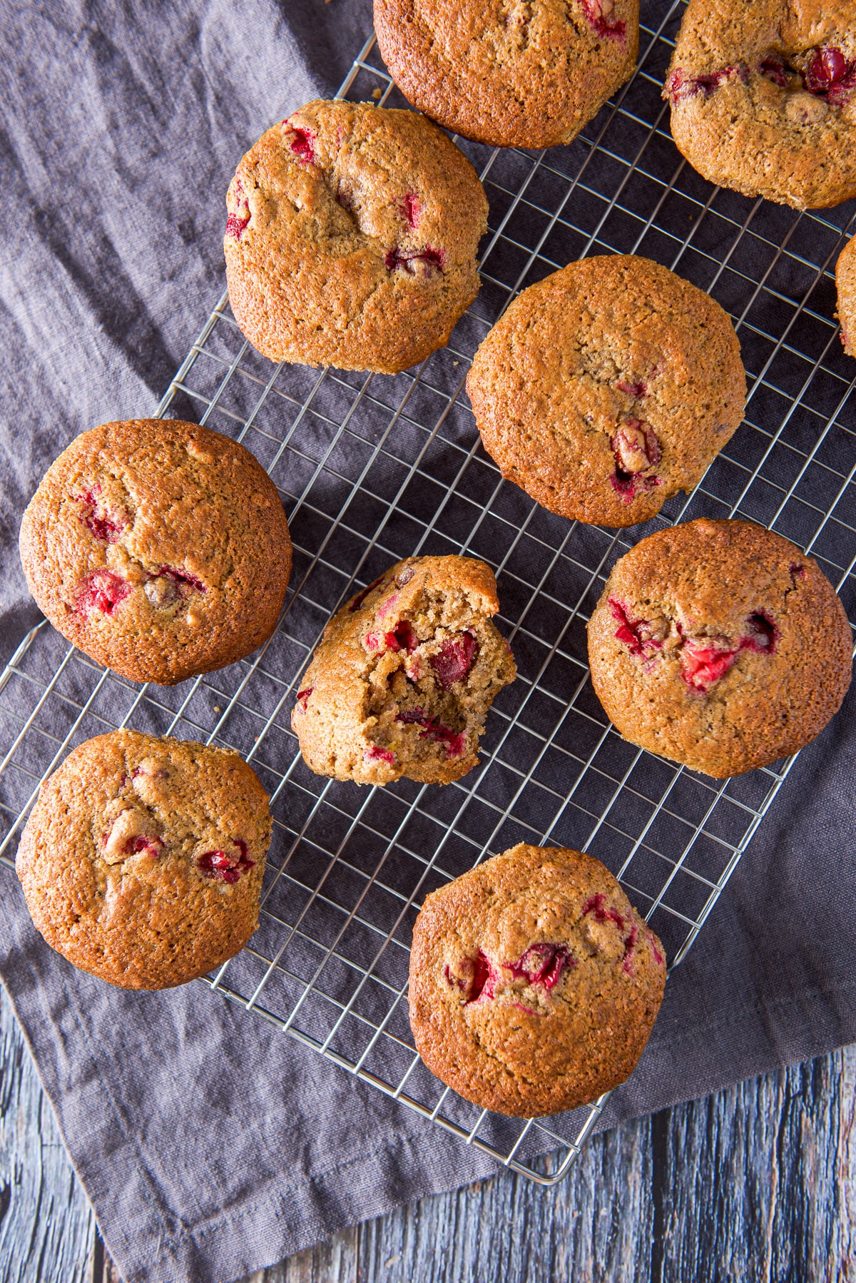 Overhead view of the muffins on the wire rack, one of the muffins has a bite taken out of it