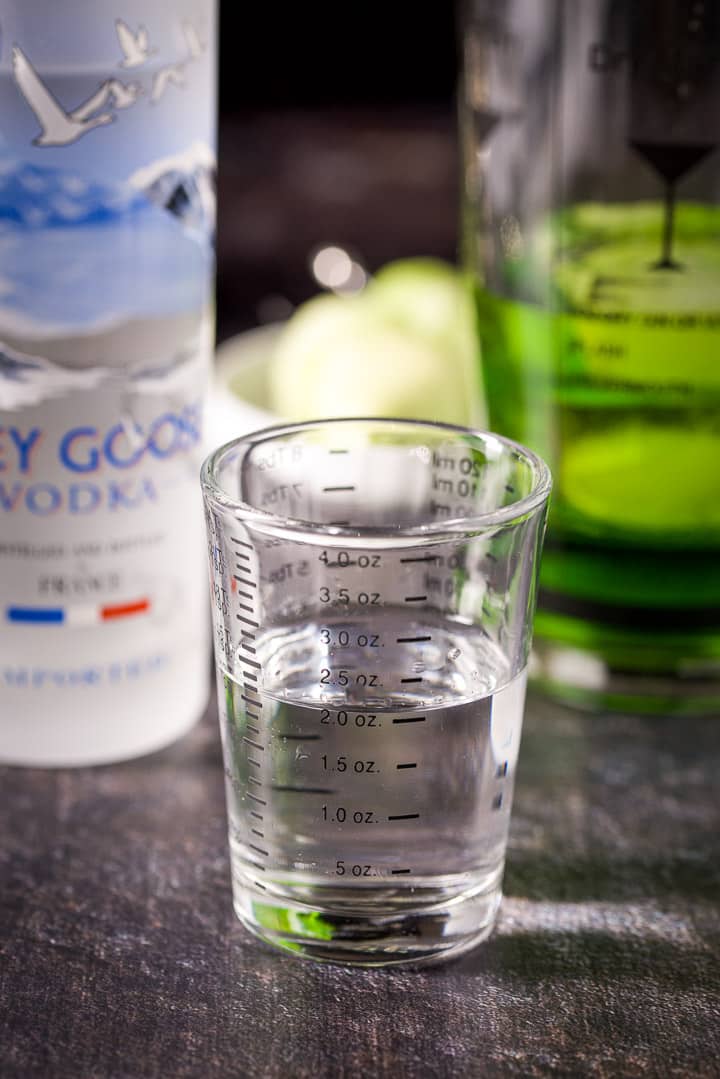 Vodka measured out with the bottle and shaker in the background
