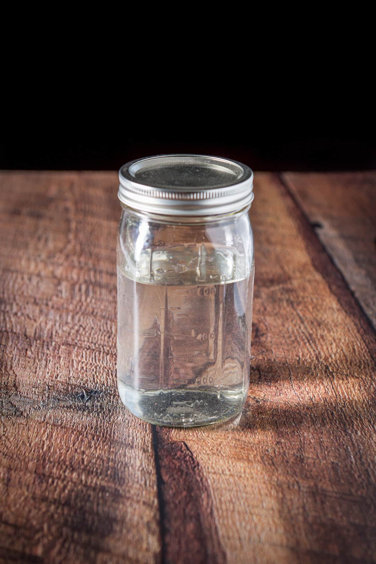 A jar of rum with the lid on it on a wooden table