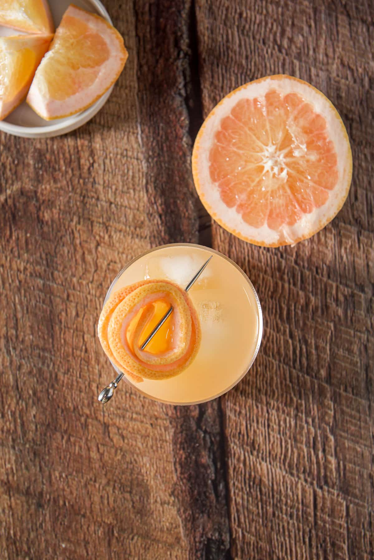 Overhead view of the cocktail with the twist garnish and chunked and sliced grapefruit with it