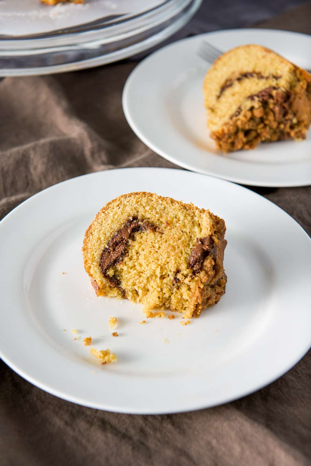 A closer view of the piece of cake with some bites taken out of it on a plate. There is another plate in the background.