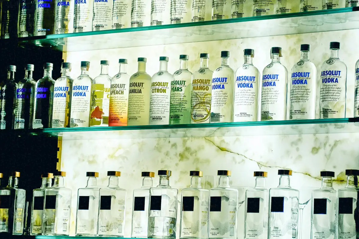 Three shelves holding multiple vodka bottles
