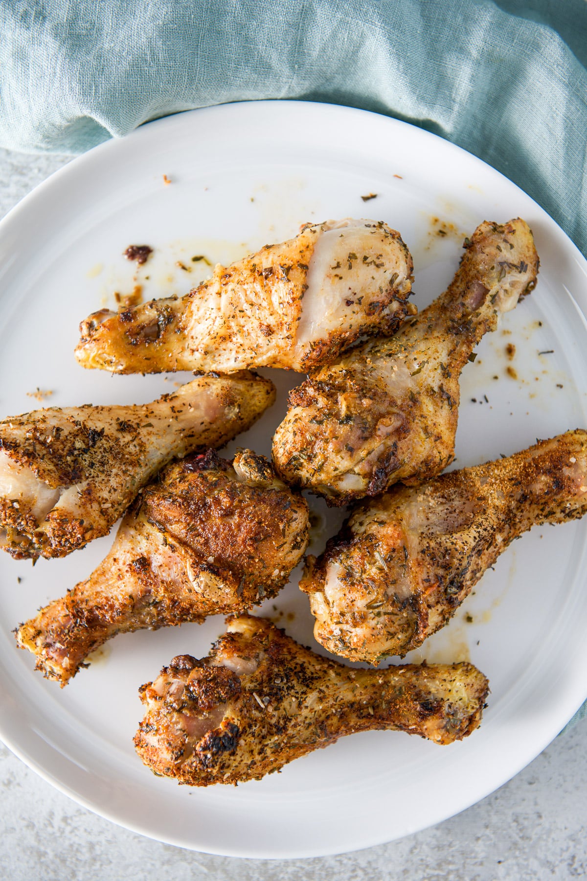 Overhead view of drumsticks on a white plate