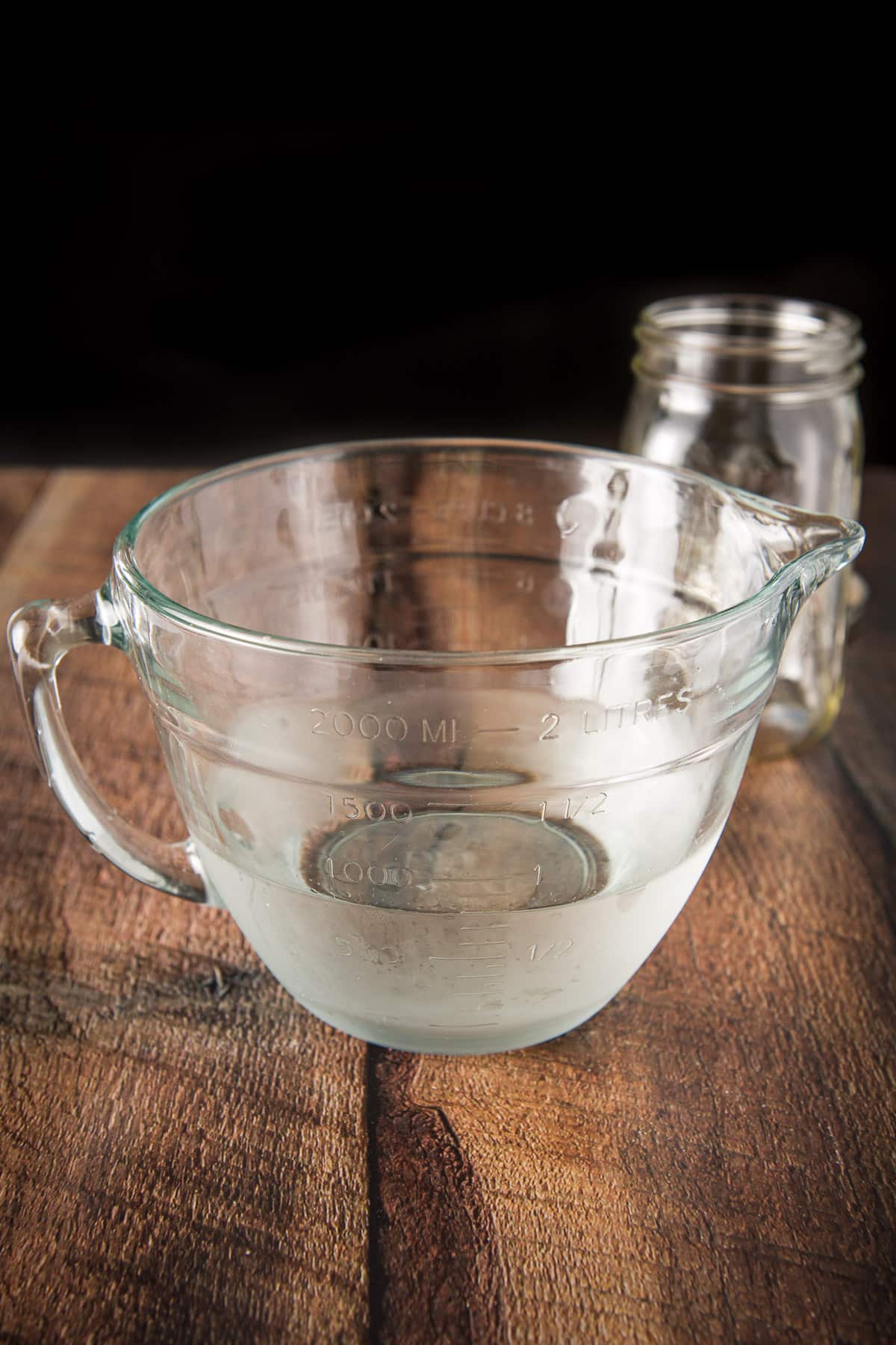 A big glass bowl with the rum after it was run through cheesecloth