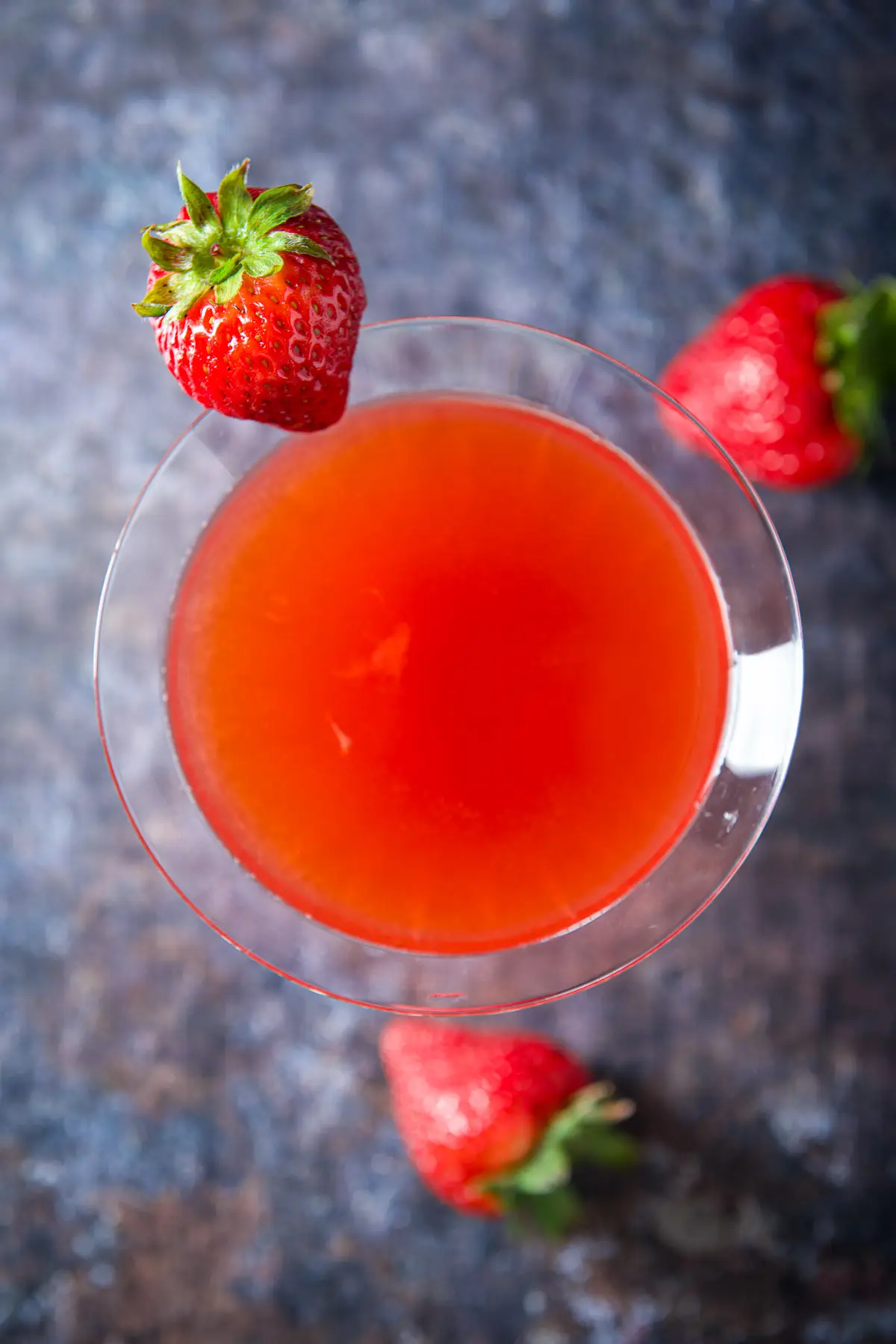 Overhead view of the red drink with strawberries and the rim and table