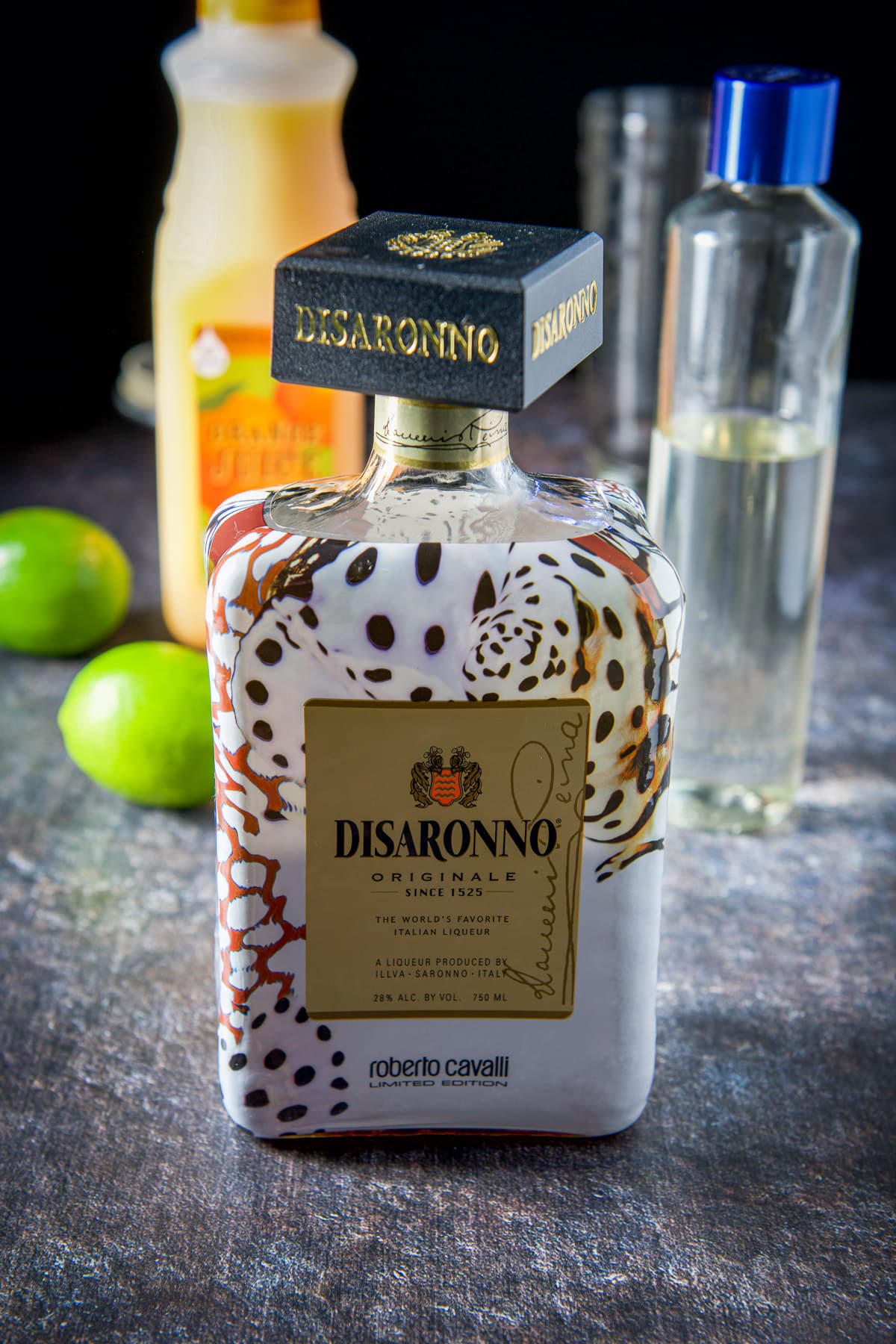 Amaretto, lime, orange juice and simple syrup on a table