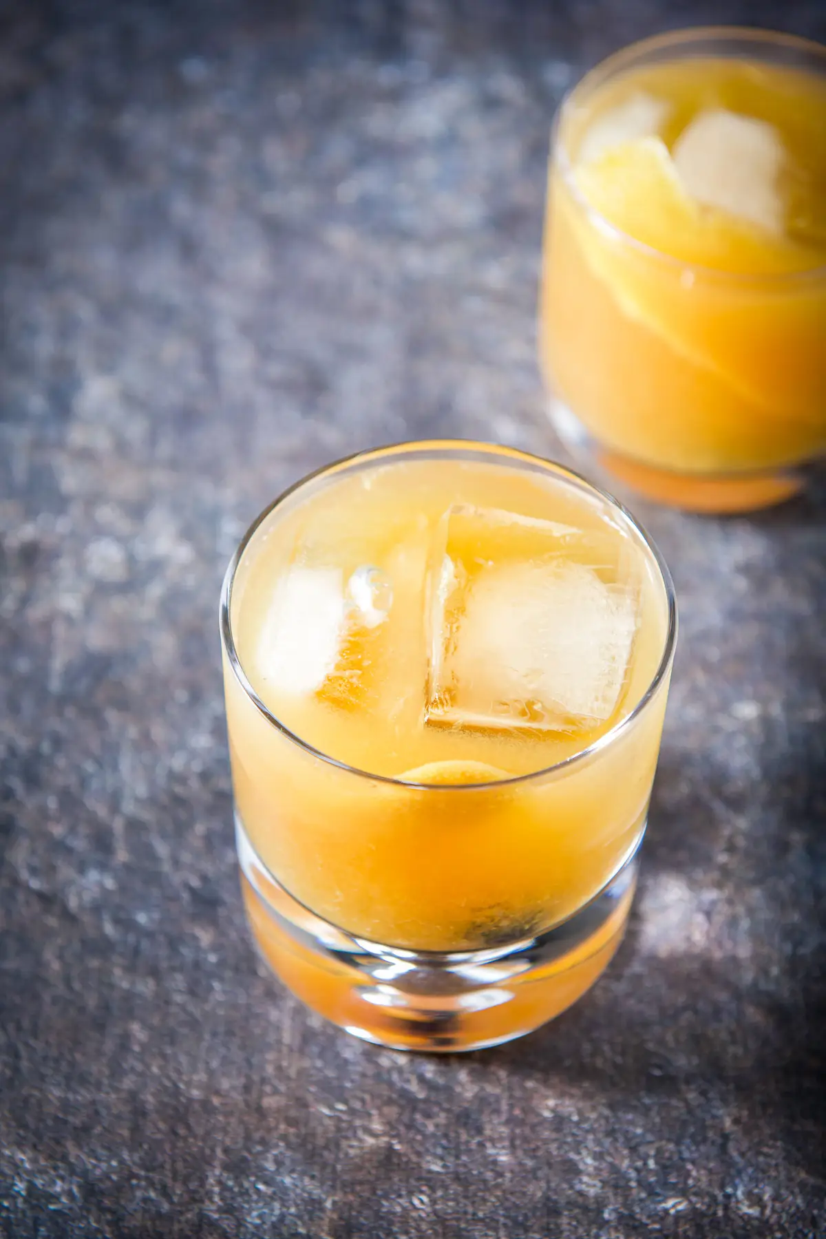 An almost overhead view of the orange juice amaretto cocktail with another in the back