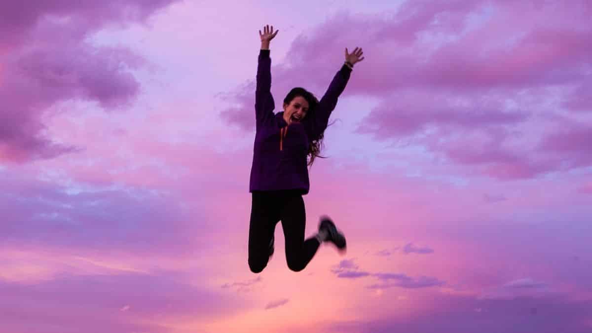 Woman jumping in the air with a beautiful sunset in the background