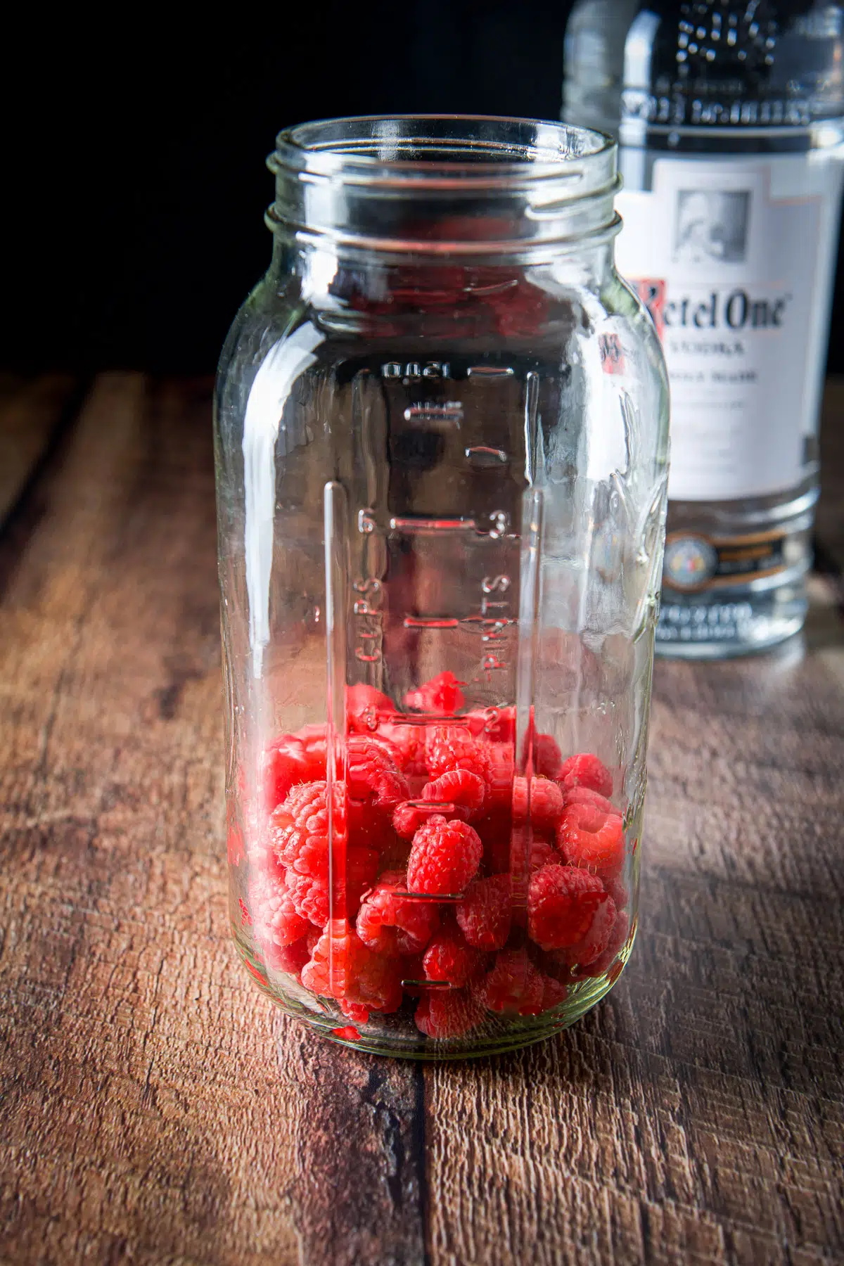 Raspberries in a large jar with the vodka in the back