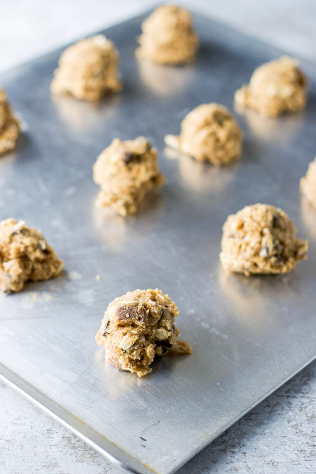 A cookie sheet with balls of dough on it