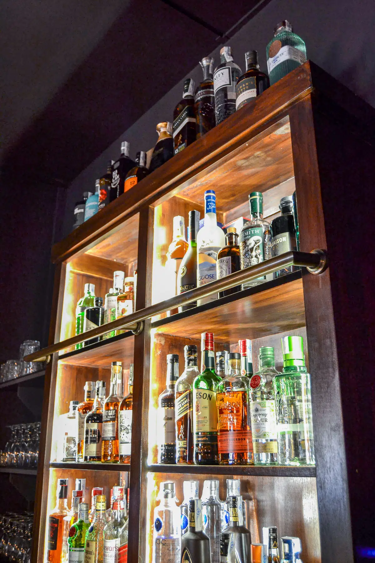 Bar photo showing lots of bottles of alcohol on wooden cabinet