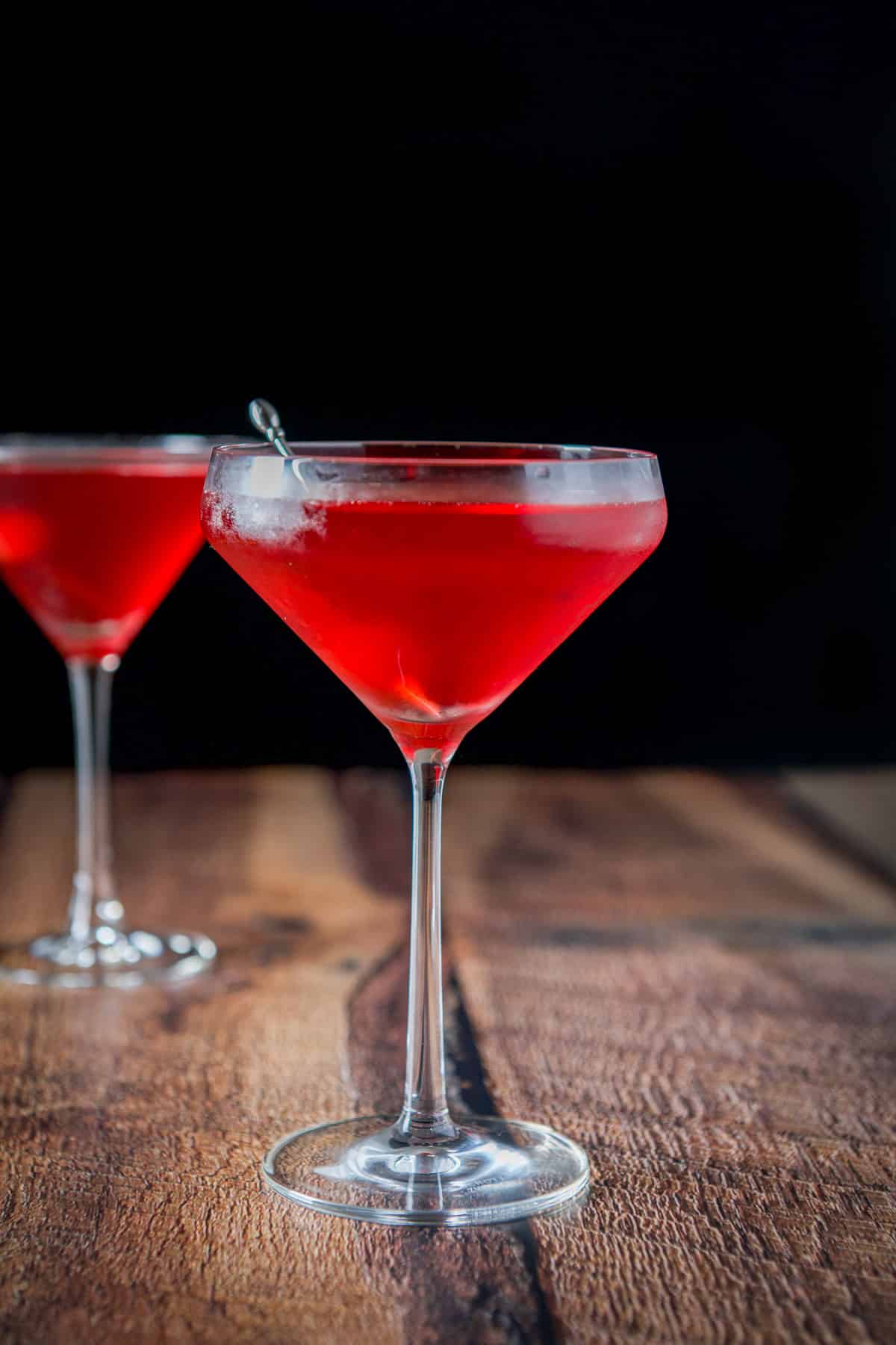 A curved glass filled with the vampire kiss in front of a martini glass