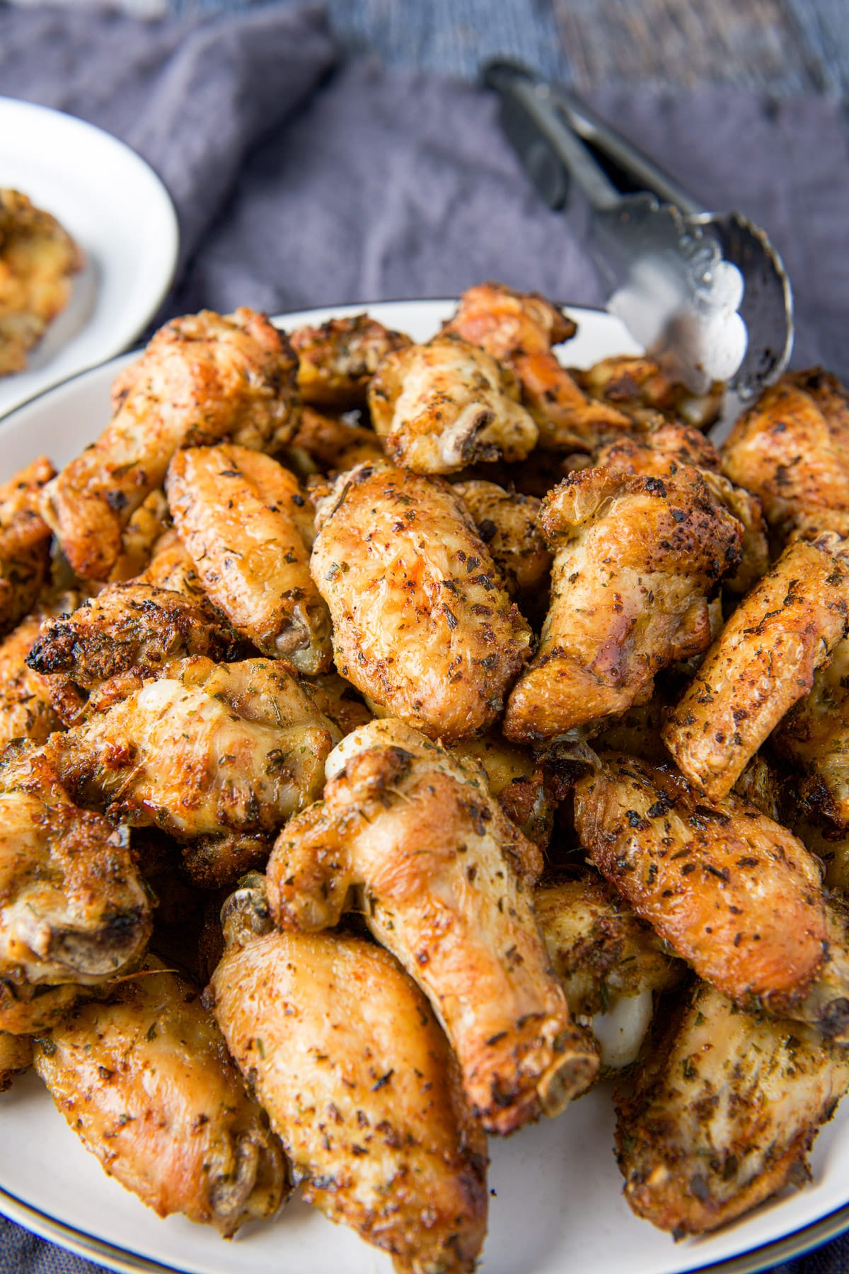 Chicken wings on a platter with a grey napkin underneath it
