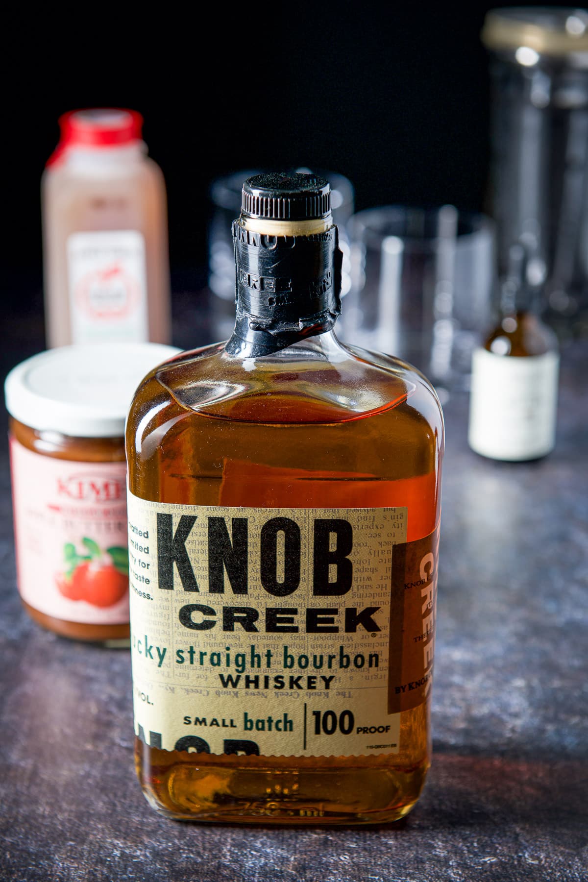 Bourbon, apple butter, cider and bitters on a table
