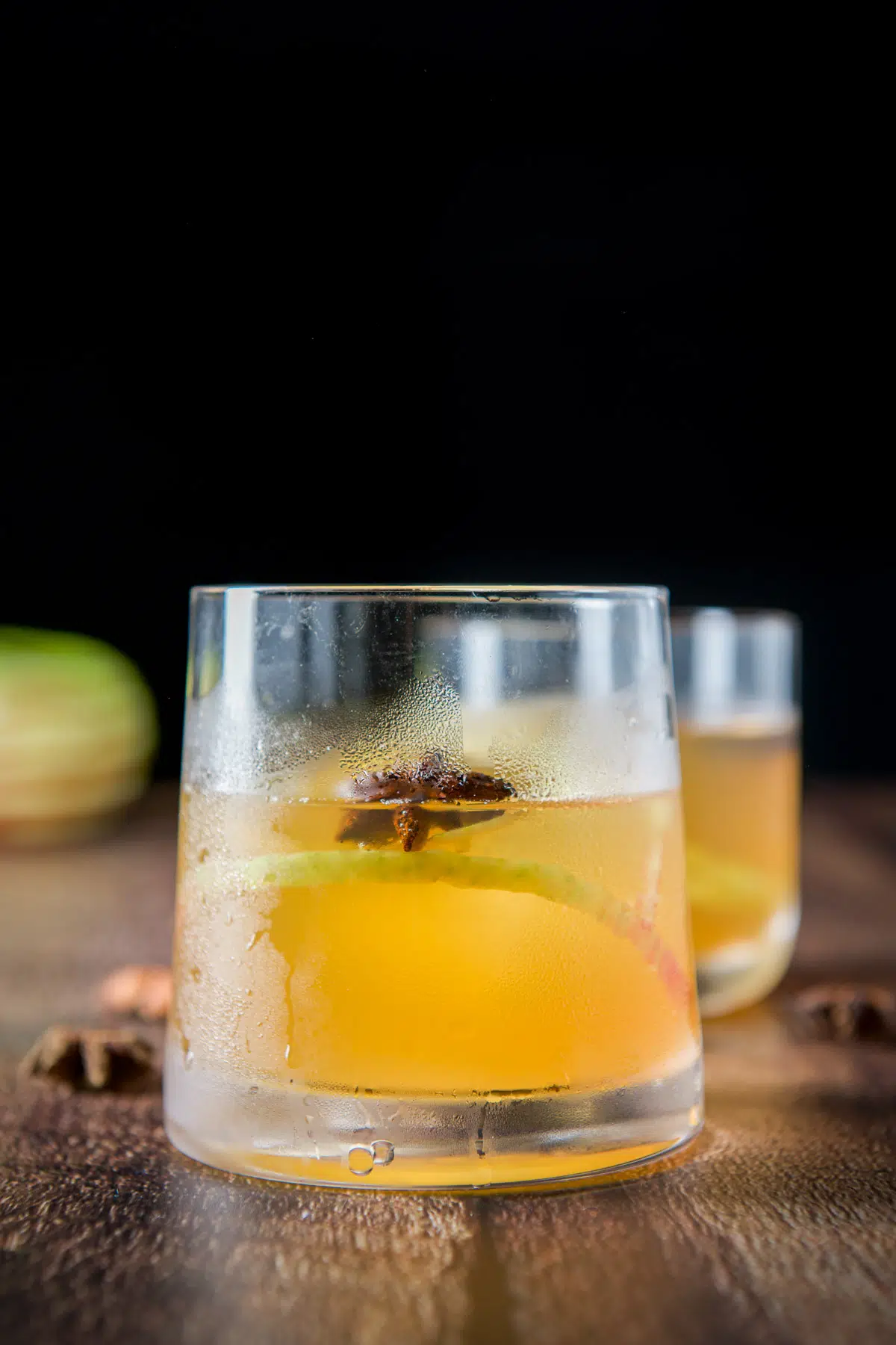 Apple cocktail in a glass with an apple skin and star anise