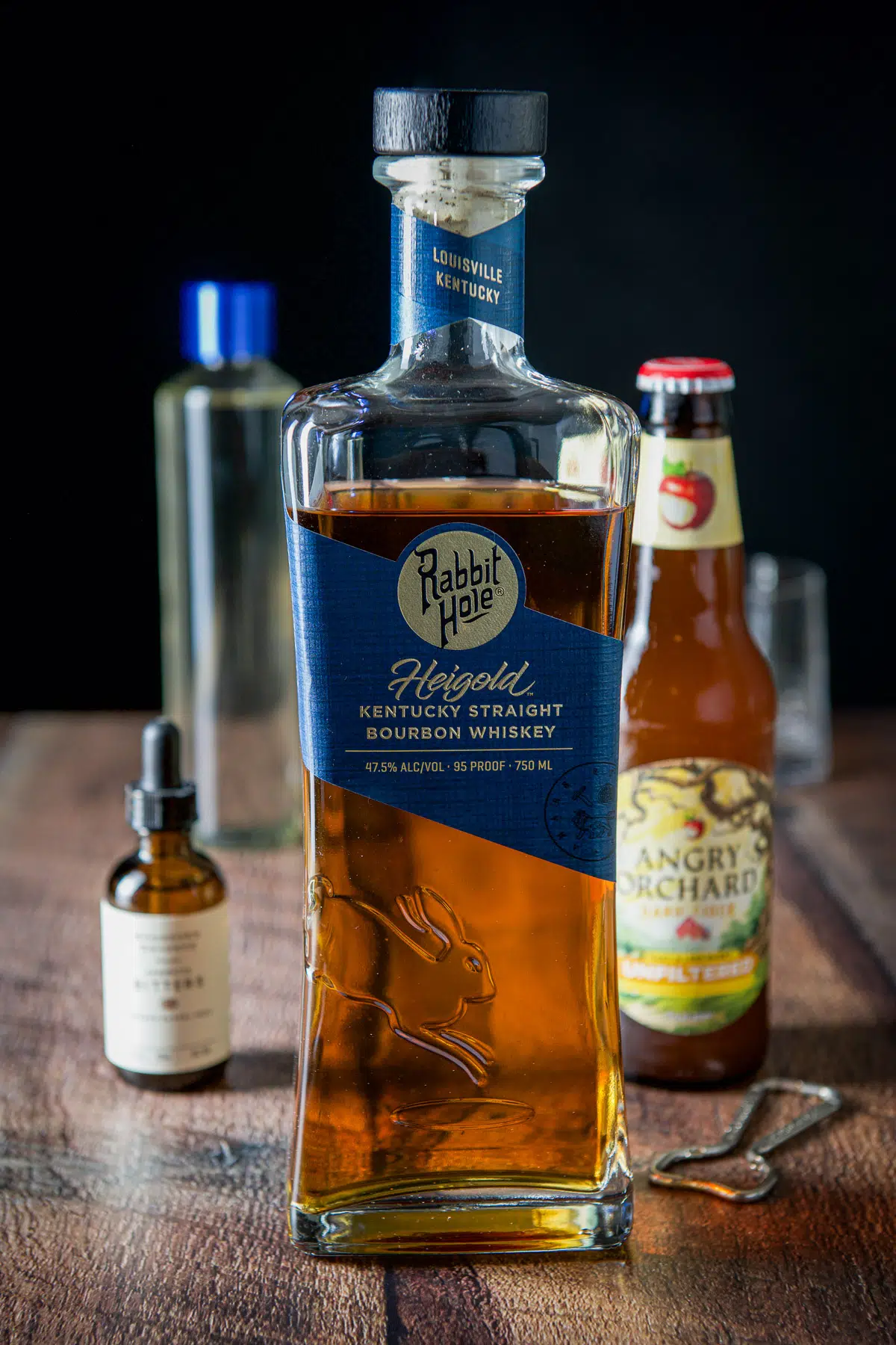 Bourbon, hard cider, bitters and simple syrup on a wood table