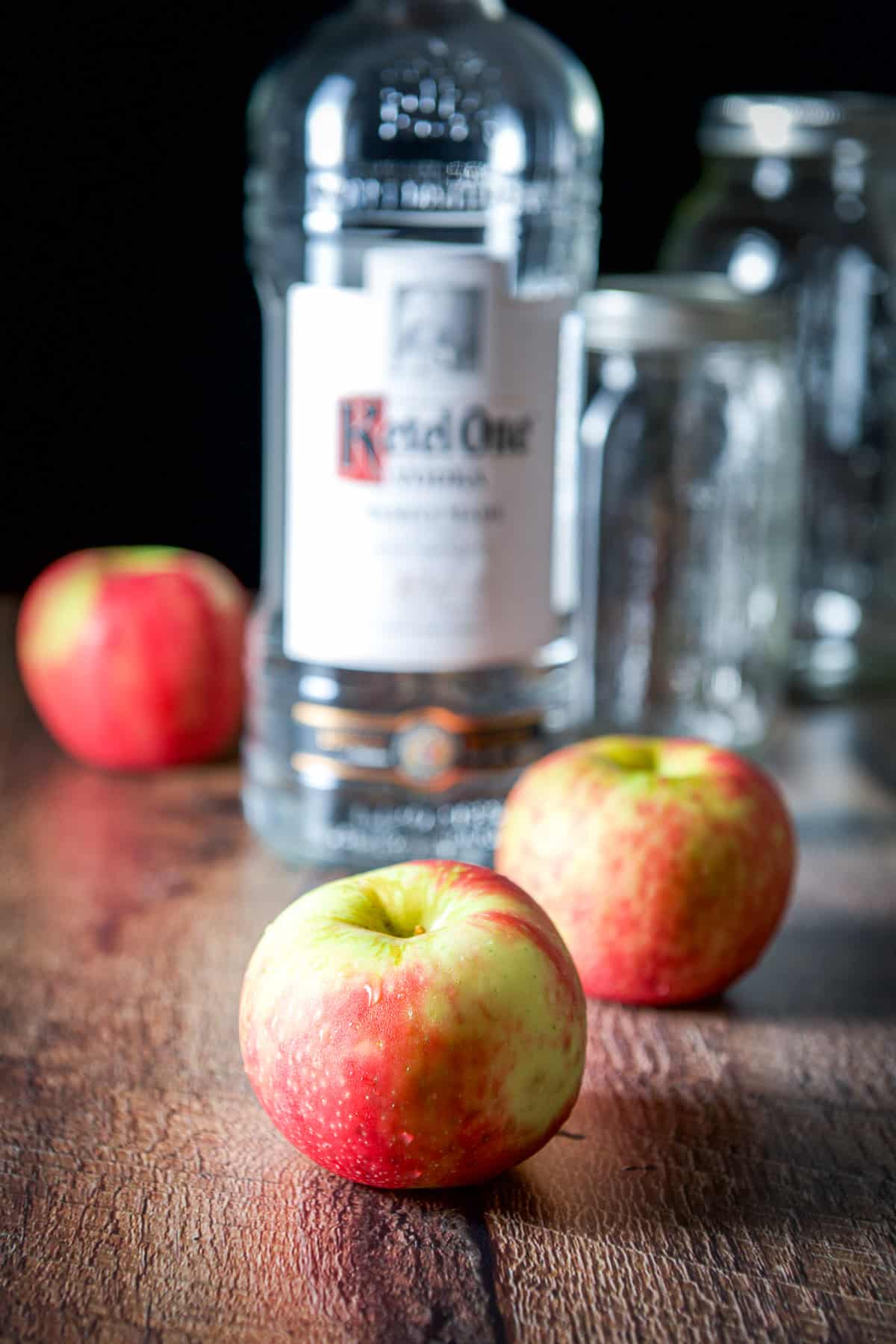 Apples in front of vodka and jars