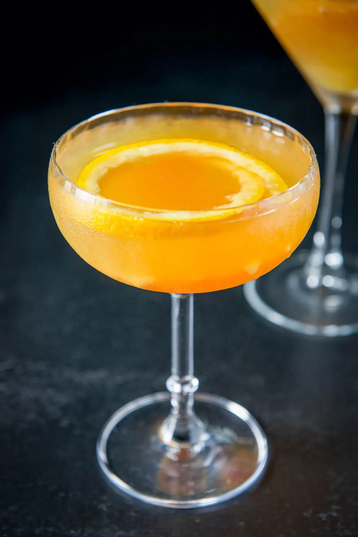 Close up of an orange drink in a coupe glass