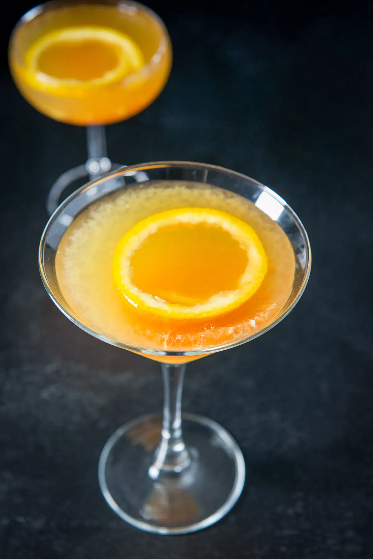 Higher view of the martini glass filled with the Bronx drink with the orange rind garnish