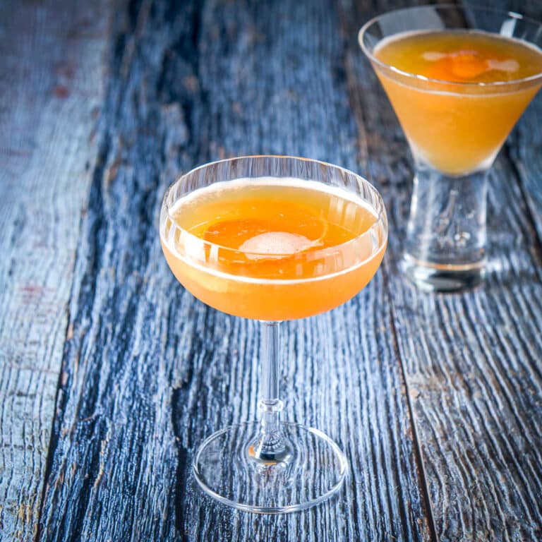 A fluted coup glass filled with the amber cocktail - square