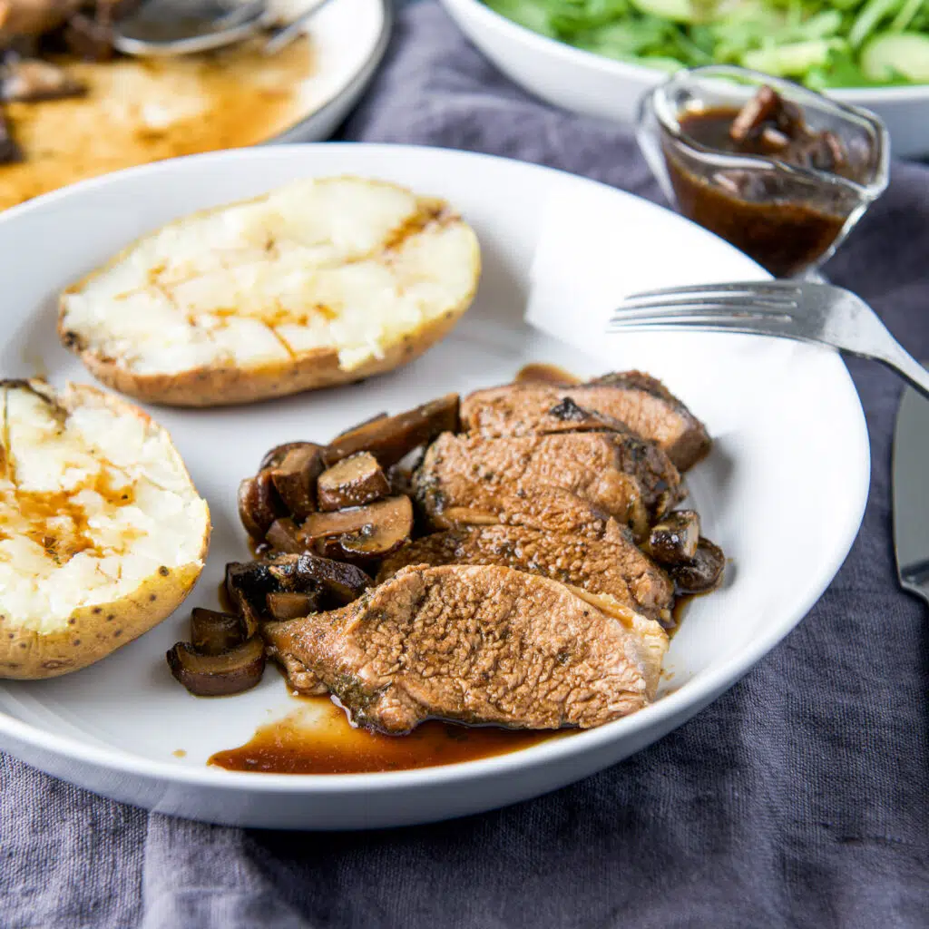 Pork slices with marinade on it with mushrooms and potato - square