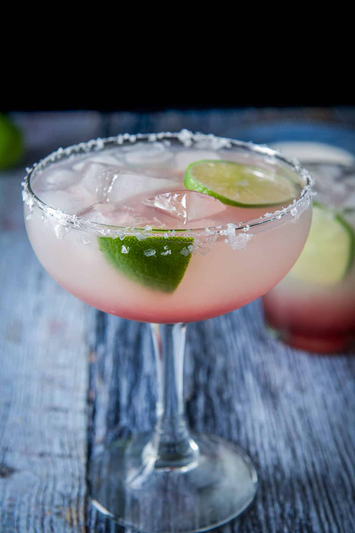 Close up of the bowl glass with salt on the edge and limes as garnish
