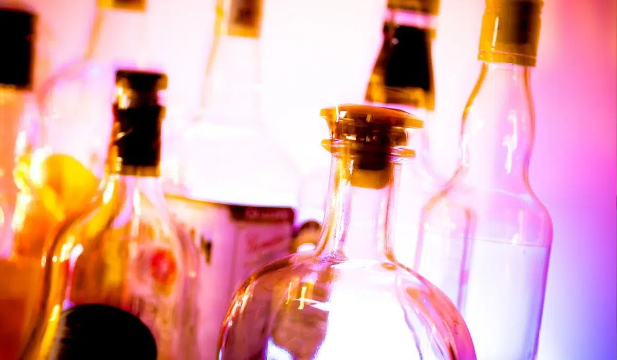 A bunch of bottles with a pink background