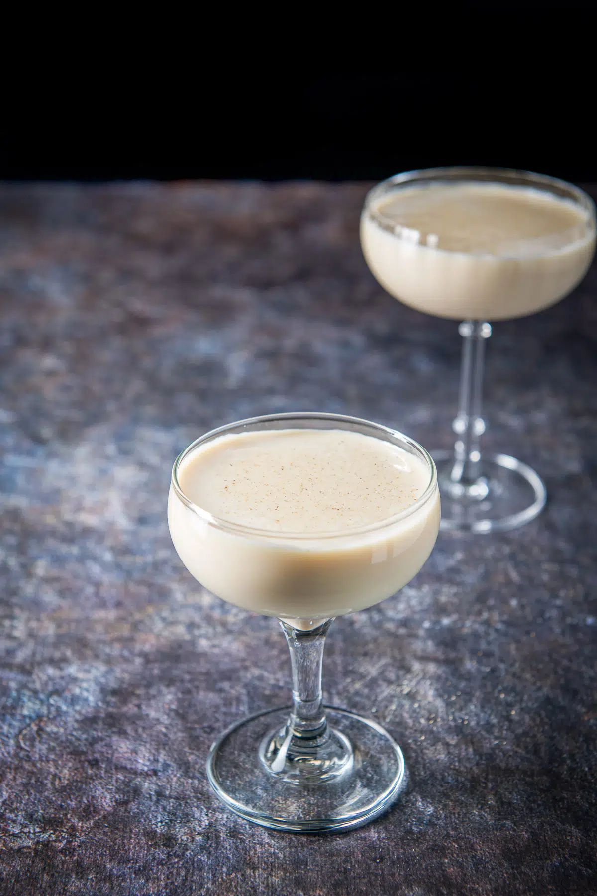 Nutmeg floating on the Brandy Alexander in the two coupe glasses