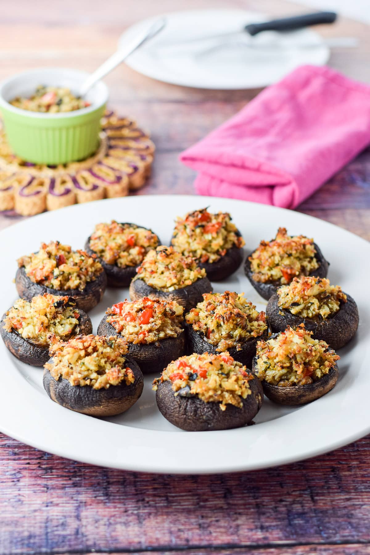A big plate with a bunch of crab mushrooms on it with more stuffing in the background