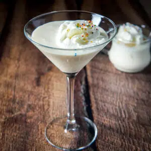 A classic glass filled with the creamy cocktail with whipped cream and sprinkles - square