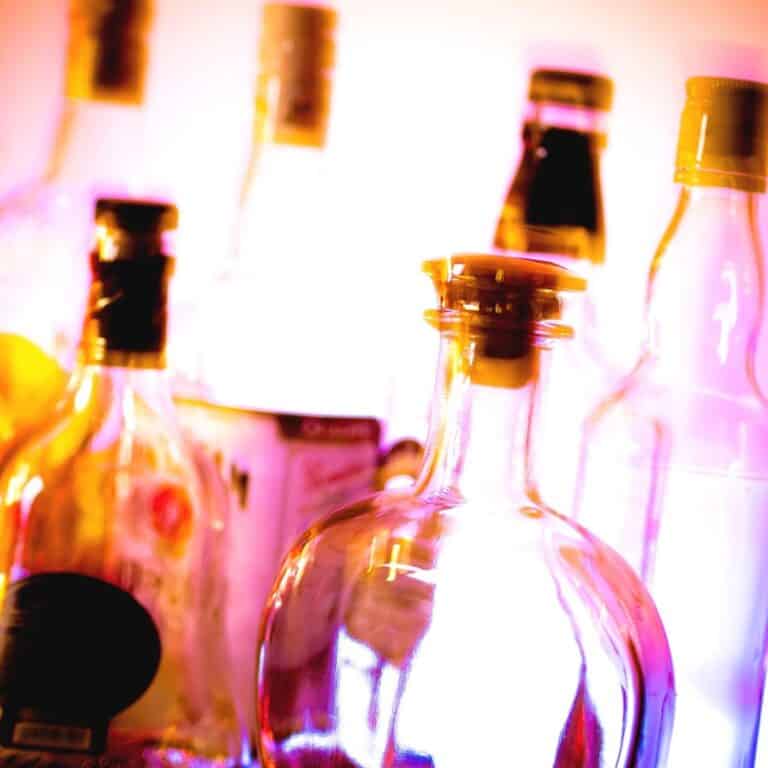 A pink background with bottles in front of it