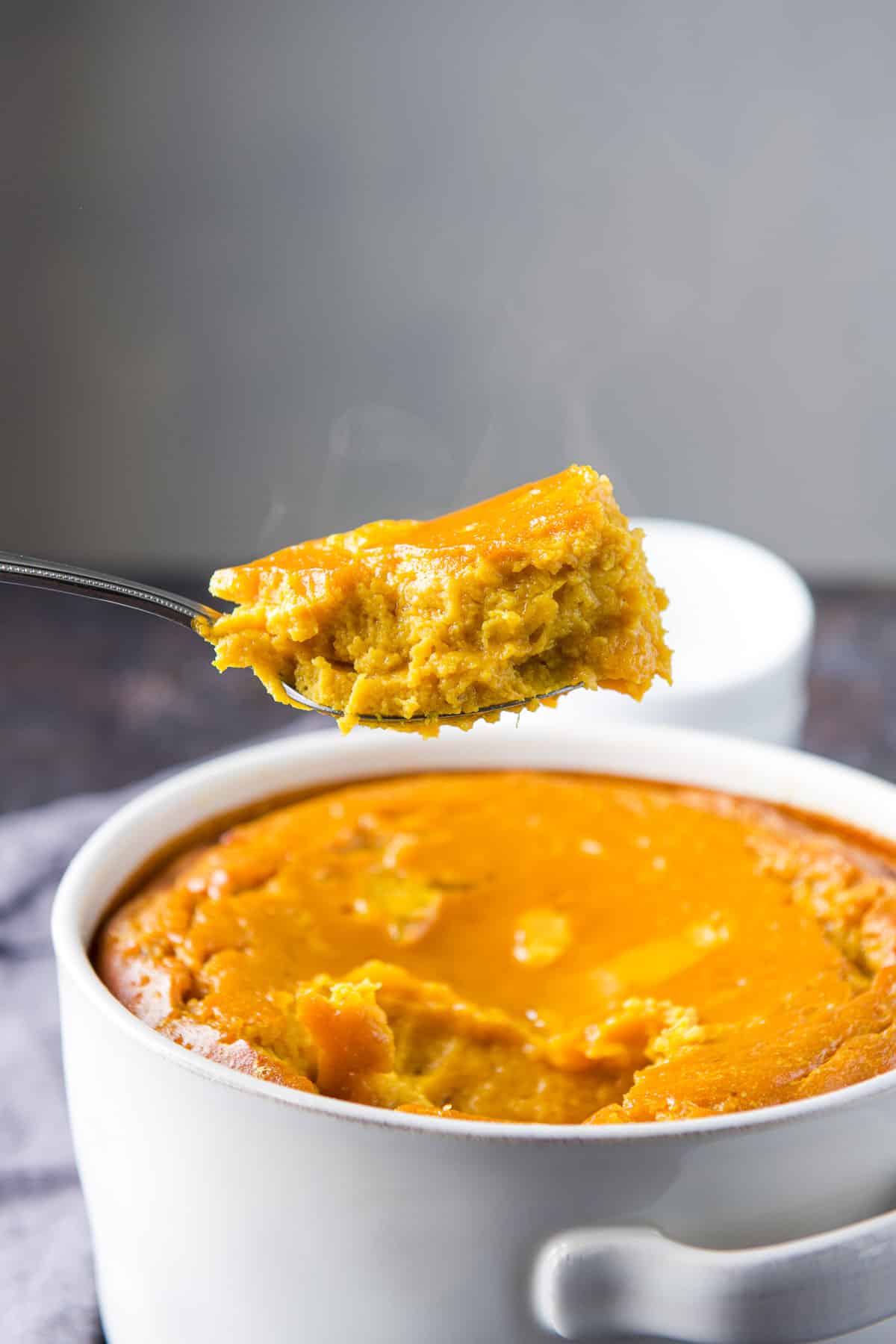 A spoon with the souffle on it held over the casserole dish