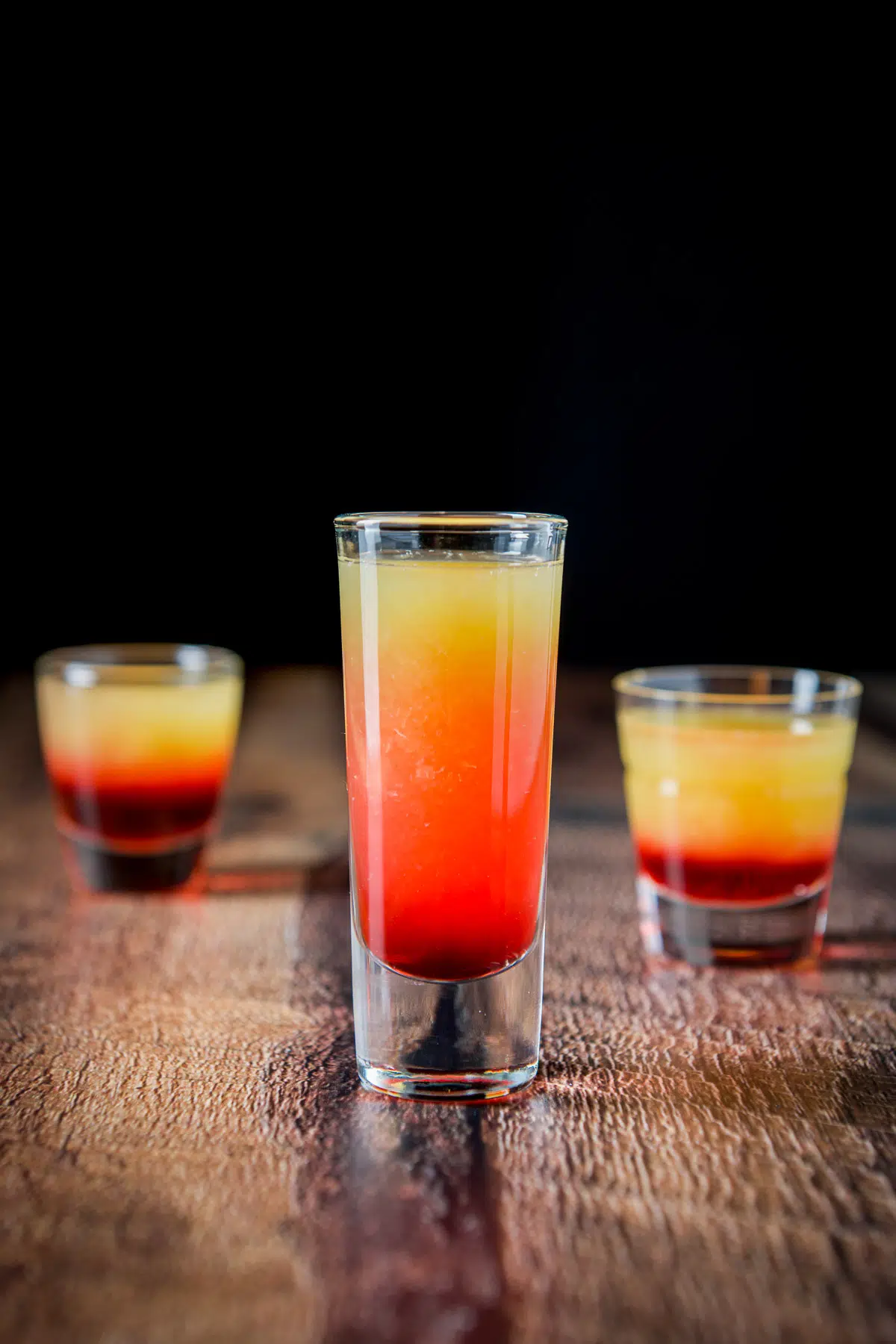 Vertical view of the tequila sunrise shot in the three glasses