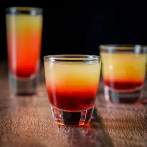 vertical view of the smooth glass filled with the tequila sunrise shot - square