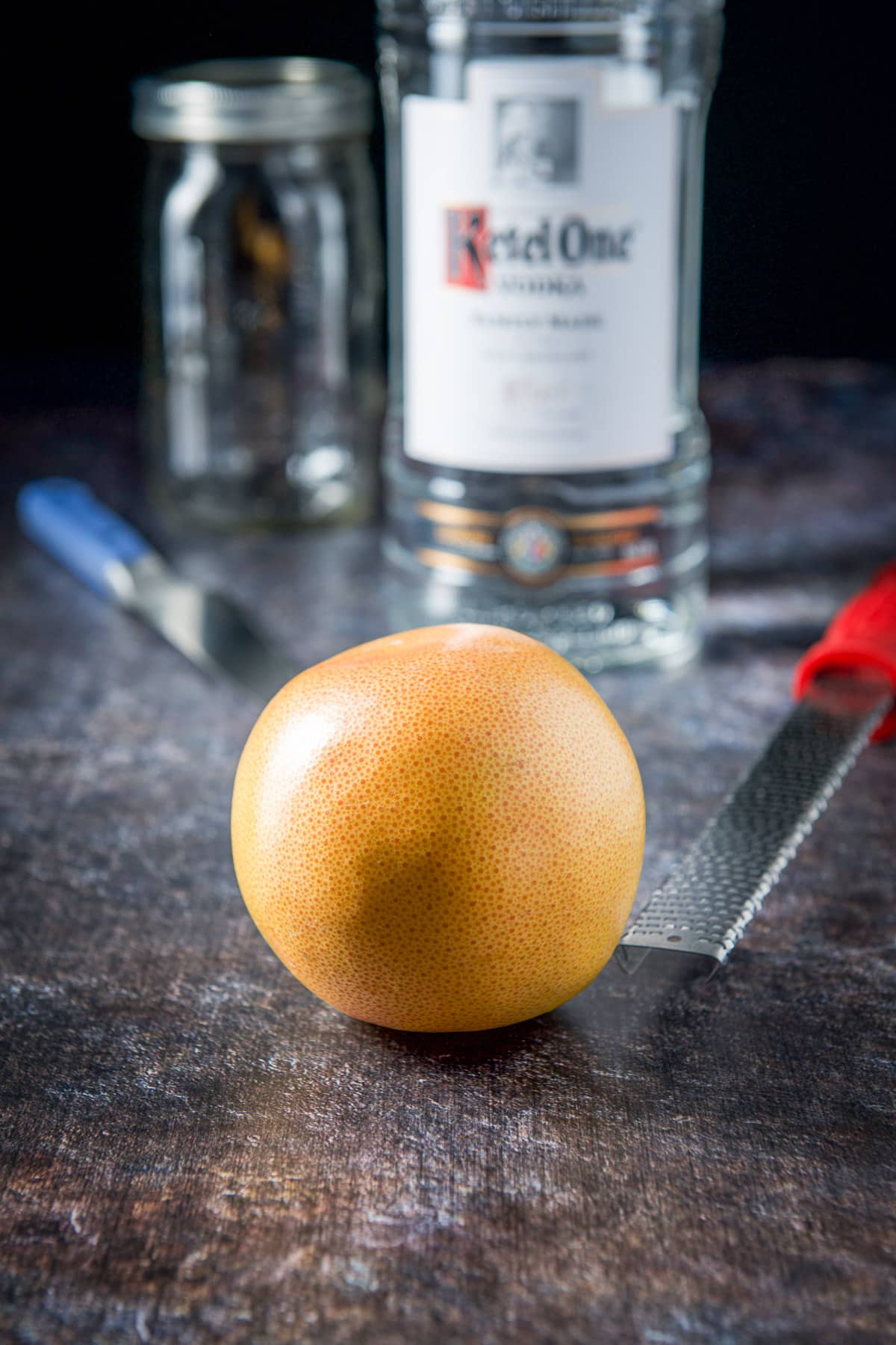 A grapefruit, microplane, vodka and jar