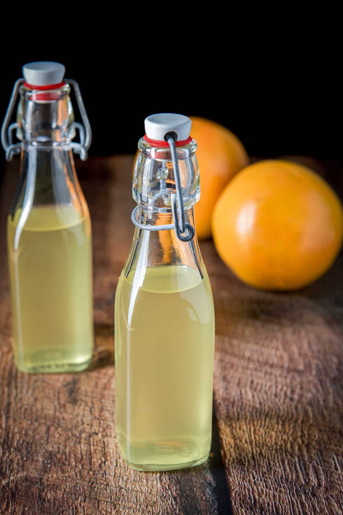 Two small bottles with the infused vodka with grapefruit in the back