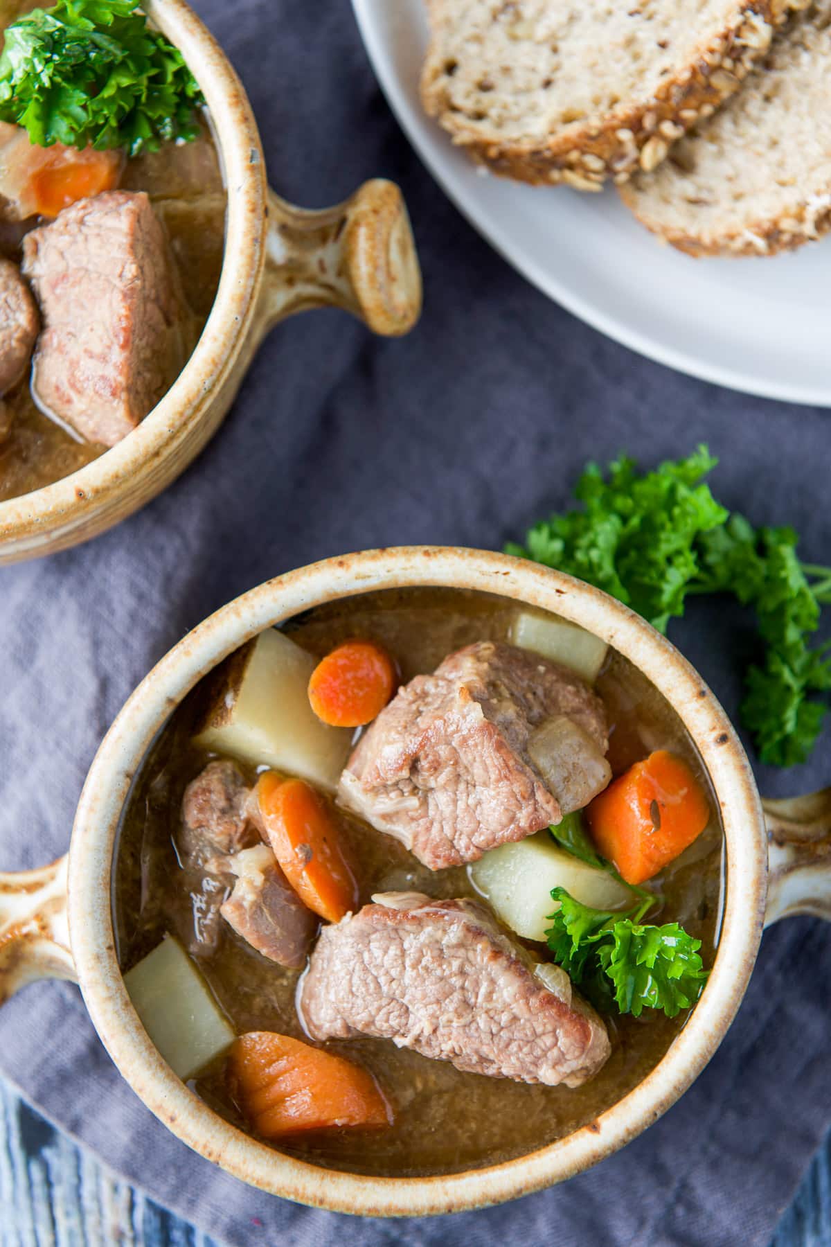 Overhead view of the lamb stew with fresh herbs and bread