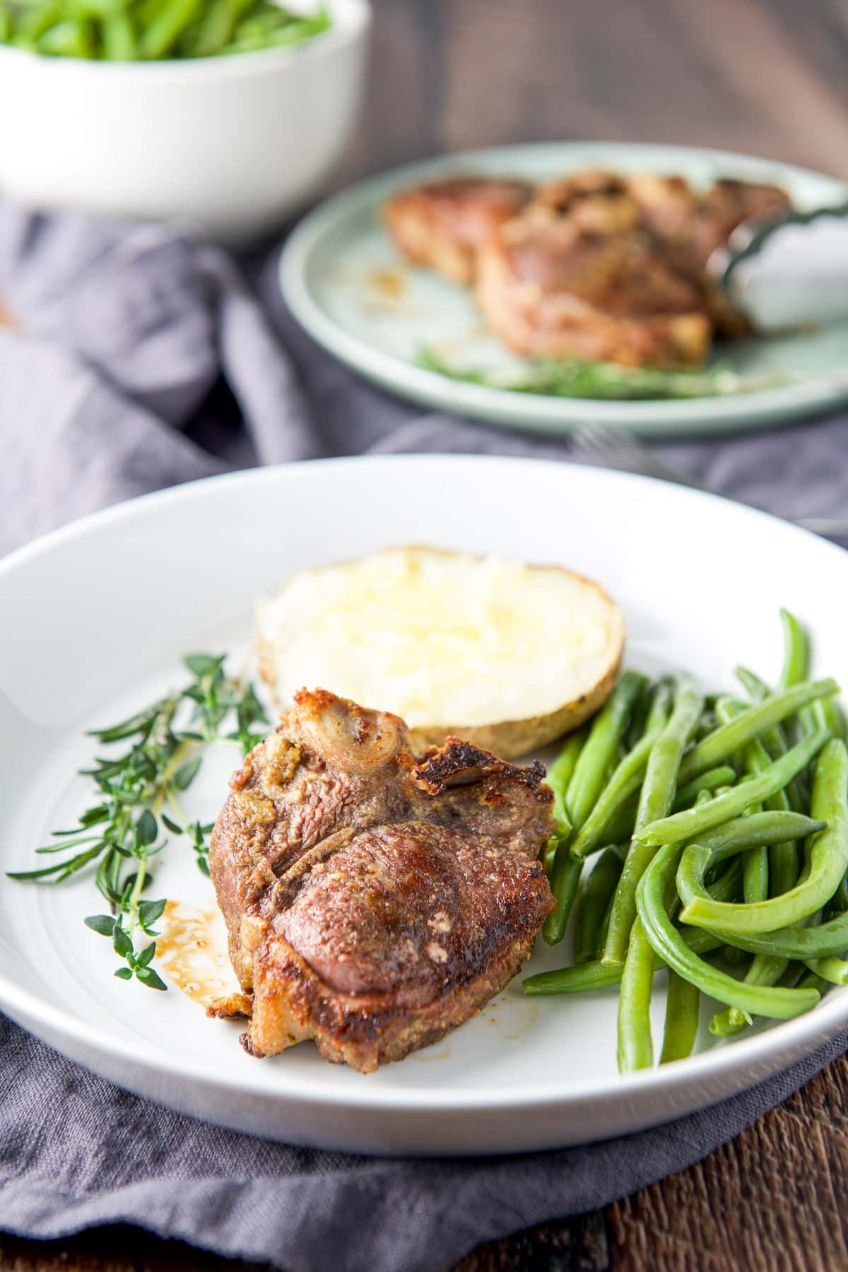 A deep plate with a lamb chop with a vegetable and potato