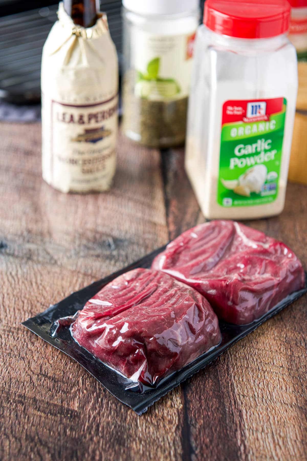 Two steaks in a package with marinade ingredients behind it